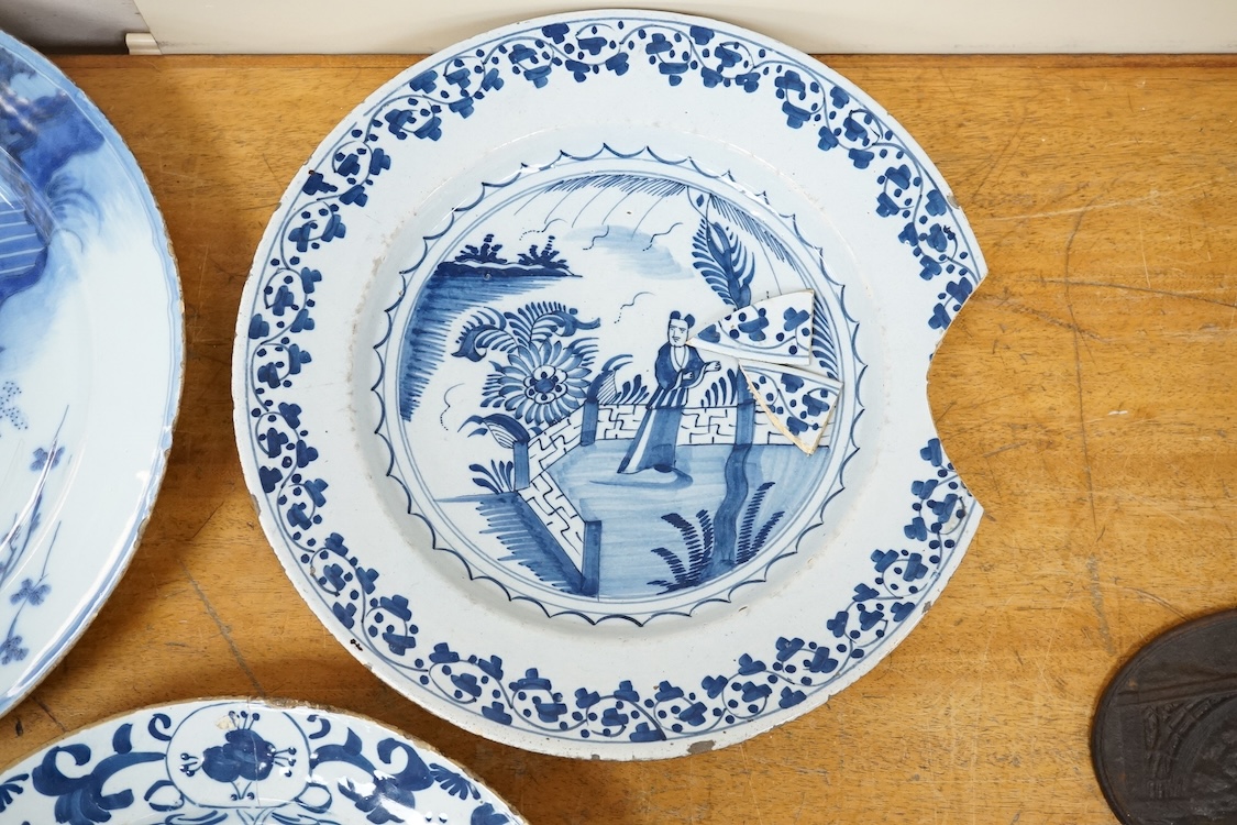 An 18th century English delftware ‘Chinese figures’ dish and two similar Delft dishes, largest 39cm diameter (3), largest 39cm